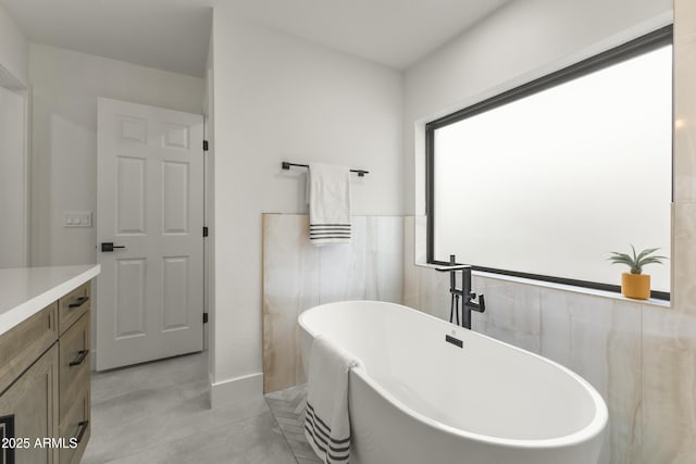 bathroom featuring vanity, tile walls, and a bathing tub