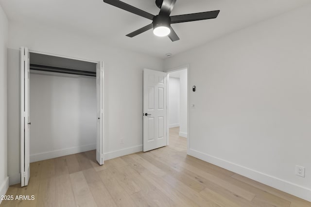 unfurnished bedroom featuring ceiling fan, light wood-type flooring, and a closet