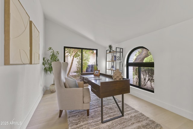 office space with light hardwood / wood-style floors and vaulted ceiling