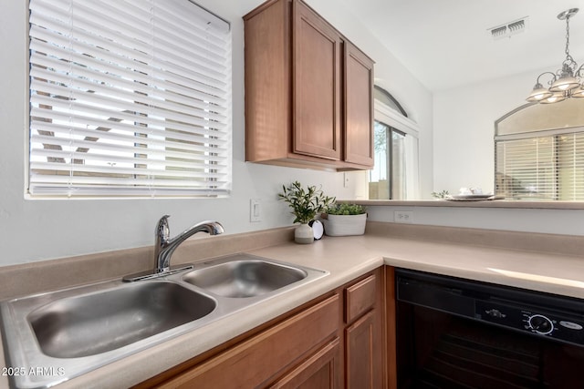 kitchen featuring sink, pendant lighting, dishwasher, and a chandelier