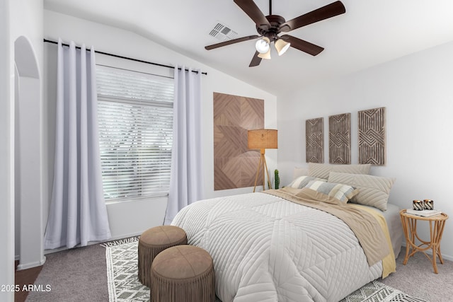 carpeted bedroom with ceiling fan and vaulted ceiling