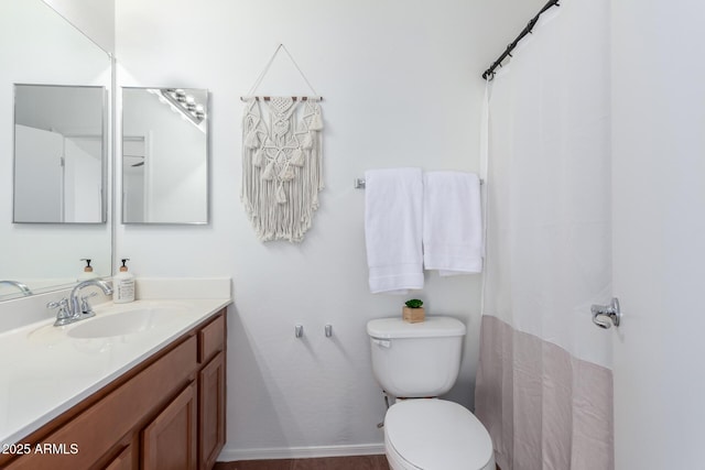 bathroom featuring toilet, curtained shower, and vanity