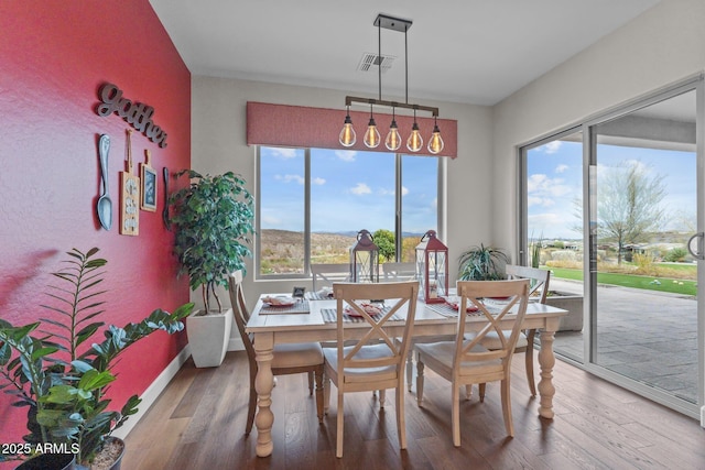 dining area featuring visible vents and wood finished floors