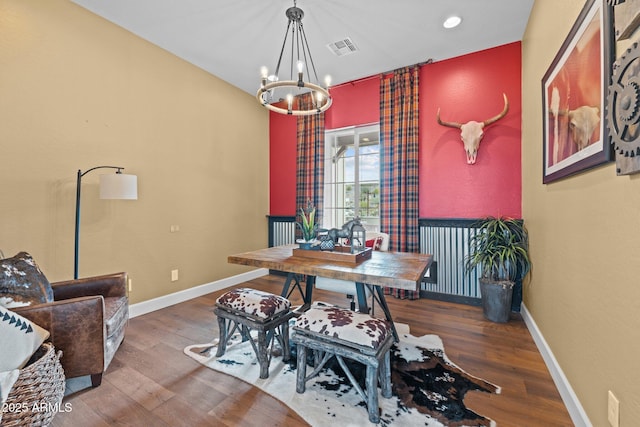 dining room featuring a chandelier, visible vents, baseboards, and wood finished floors