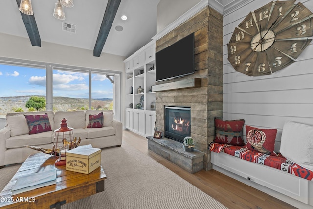 living area featuring visible vents, beamed ceiling, wood finished floors, recessed lighting, and a stone fireplace