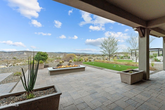 view of patio / terrace featuring a mountain view and a fire pit