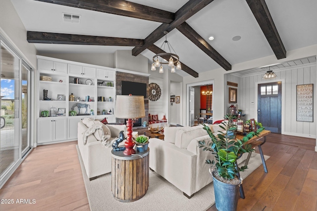 living area with lofted ceiling with beams, visible vents, a chandelier, and light wood finished floors