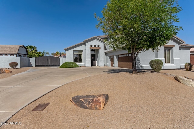 view of front facade featuring stucco siding, driveway, a garage, and a gate