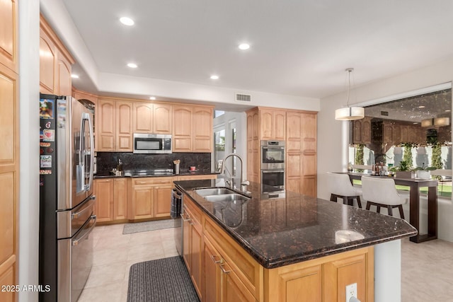 kitchen with tasteful backsplash, visible vents, light brown cabinets, appliances with stainless steel finishes, and a sink