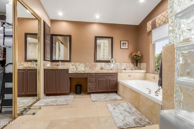 full bath featuring tile patterned flooring, double vanity, a bath, and a sink