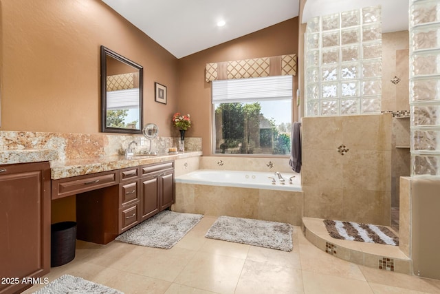 full bathroom featuring vanity, lofted ceiling, walk in shower, a garden tub, and tile patterned floors