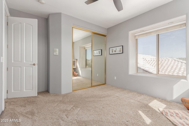 unfurnished bedroom featuring a closet, carpet, and ceiling fan