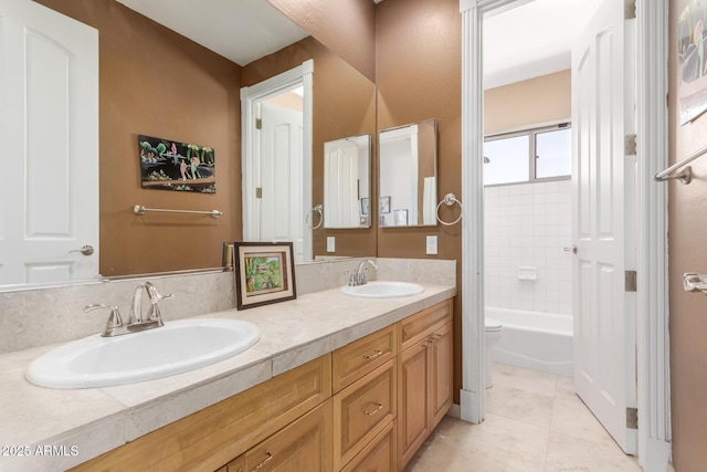 full bathroom with a sink, toilet, double vanity, and tile patterned floors