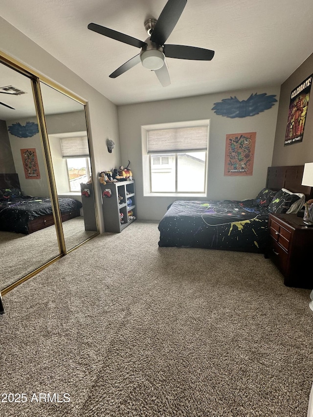 carpeted bedroom featuring visible vents, a closet, and ceiling fan