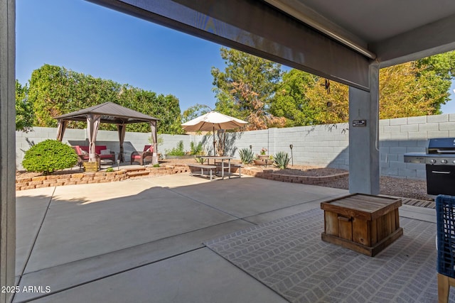 view of patio featuring a gazebo, a fenced backyard, and grilling area