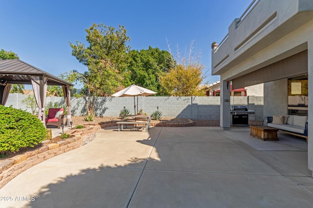 view of patio featuring a gazebo, an outdoor hangout area, a fenced backyard, and grilling area