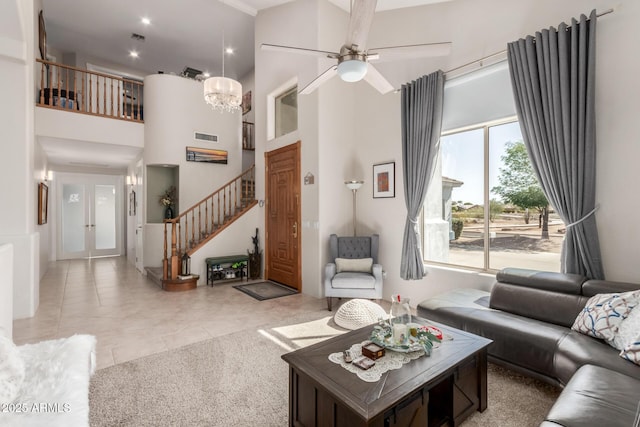 living room with light tile patterned floors, visible vents, stairs, french doors, and a towering ceiling