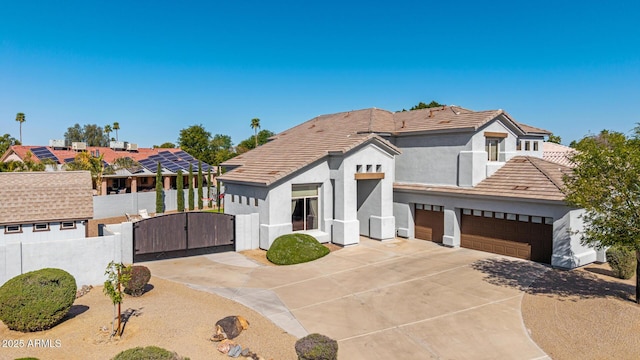 view of front of home with fence, stucco siding, a garage, driveway, and a gate