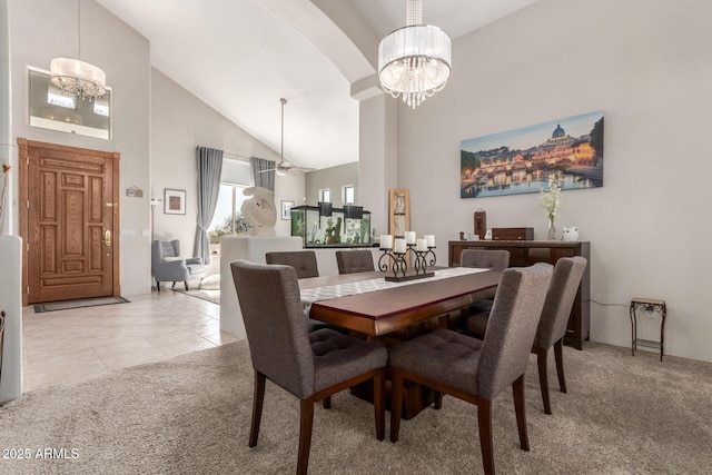 dining room with light tile patterned floors, light carpet, a notable chandelier, and high vaulted ceiling