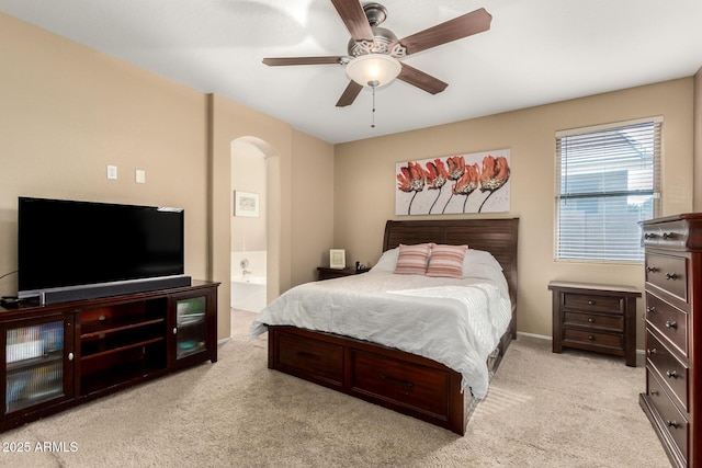 carpeted bedroom with ceiling fan and ensuite bath