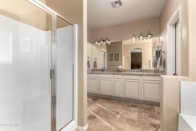 bathroom featuring an enclosed shower and vanity