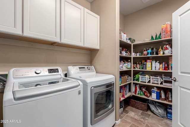 clothes washing area featuring cabinets and washer and dryer