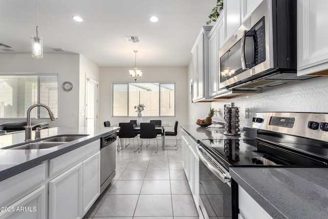 20496 W Valley View Dr, Buckeye, AZ 85396 - kitchen with stainless steel appliances, a sink, a chandelier, hanging light fixtures, and recessed lighting