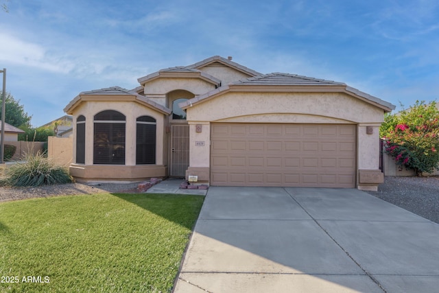 view of front of home featuring fence, driveway, an attached garage, stucco siding, and a front lawn