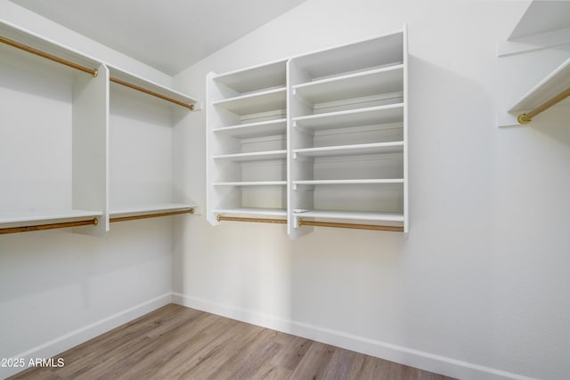 walk in closet featuring lofted ceiling and wood finished floors