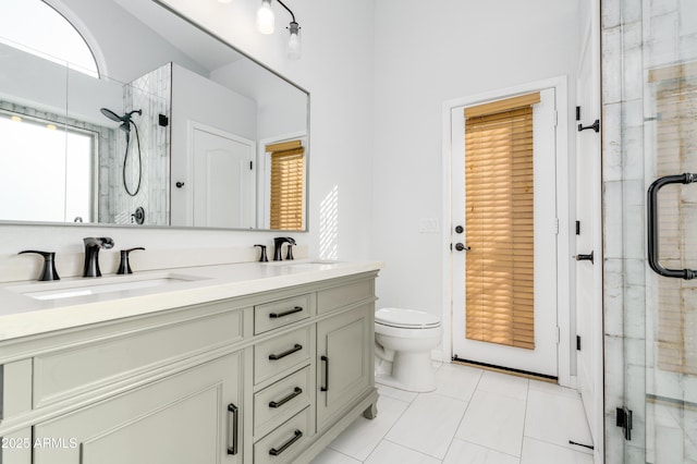 full bath with a shower stall, double vanity, and a sink