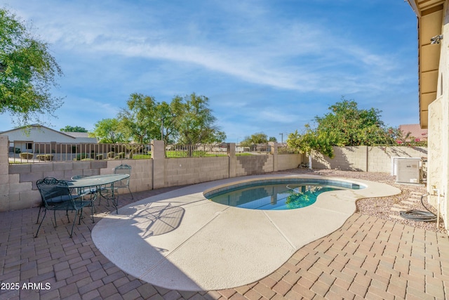 view of pool with a patio area, outdoor dining space, a fenced in pool, and a fenced backyard