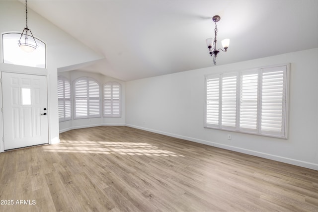 foyer entrance with an inviting chandelier, lofted ceiling, wood finished floors, and baseboards