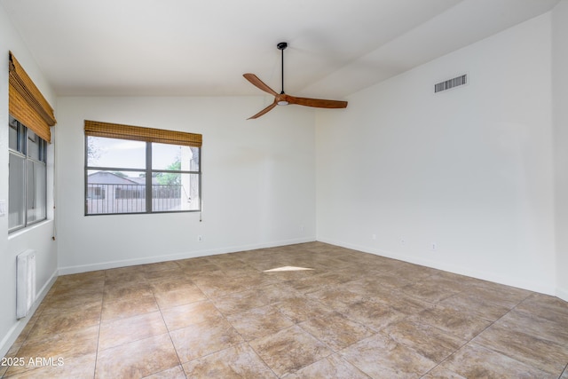 spare room with visible vents, baseboards, ceiling fan, and vaulted ceiling