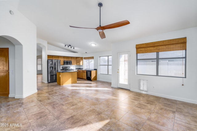 kitchen featuring dark countertops, ceiling fan, open floor plan, brown cabinets, and stainless steel appliances