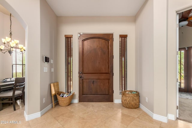 tiled foyer entrance with a chandelier