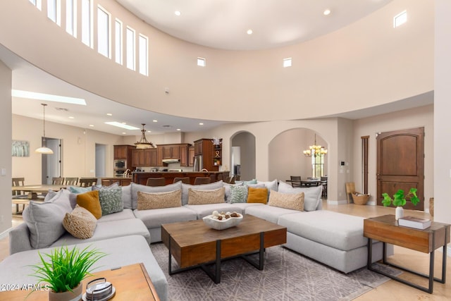 living room with a towering ceiling and a chandelier