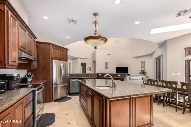 kitchen featuring a kitchen island with sink, sink, decorative light fixtures, and appliances with stainless steel finishes