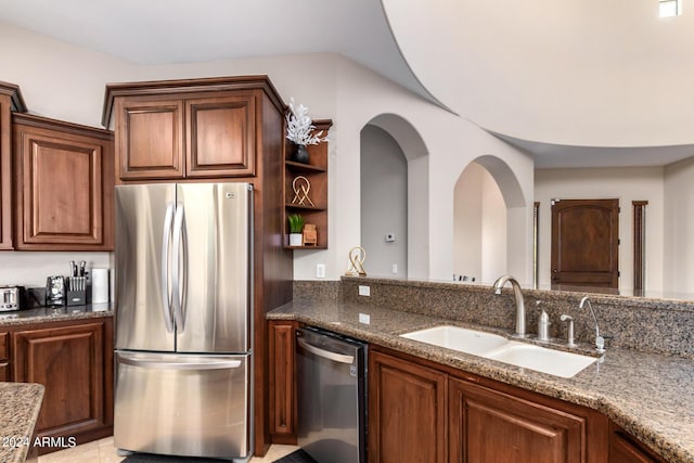 kitchen with stainless steel appliances, sink, and stone counters