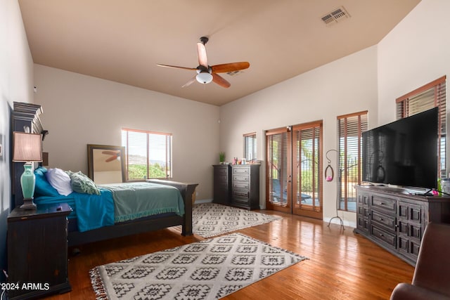 bedroom with access to exterior, wood-type flooring, and ceiling fan