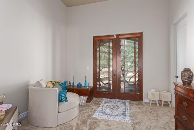 sitting room with light colored carpet and french doors