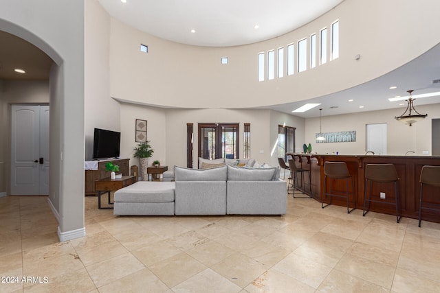 living room featuring a towering ceiling and a healthy amount of sunlight