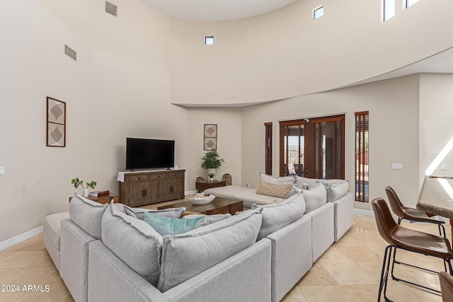 tiled living room featuring a high ceiling