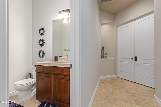 bathroom featuring vanity, tile patterned floors, and toilet