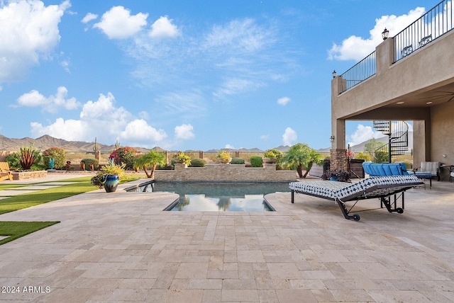 view of swimming pool featuring a mountain view and a patio area