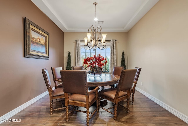 dining room featuring a notable chandelier, a tray ceiling, and dark hardwood / wood-style floors