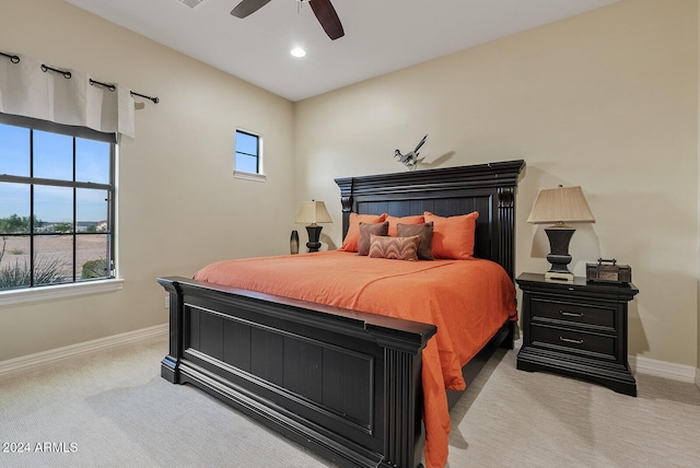 bedroom with multiple windows, light colored carpet, and ceiling fan