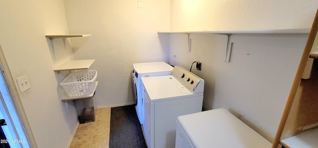 laundry area with washer and clothes dryer and tile patterned flooring