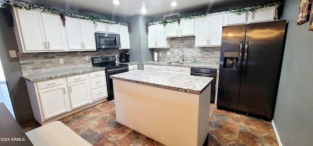 kitchen with white cabinets, a kitchen island, sink, and appliances with stainless steel finishes