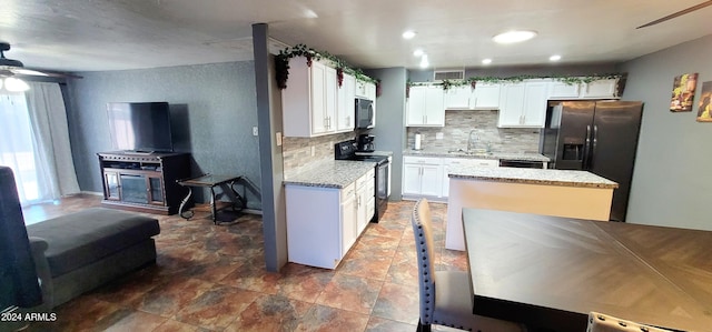 kitchen with white cabinetry, sink, black electric range oven, and refrigerator with ice dispenser