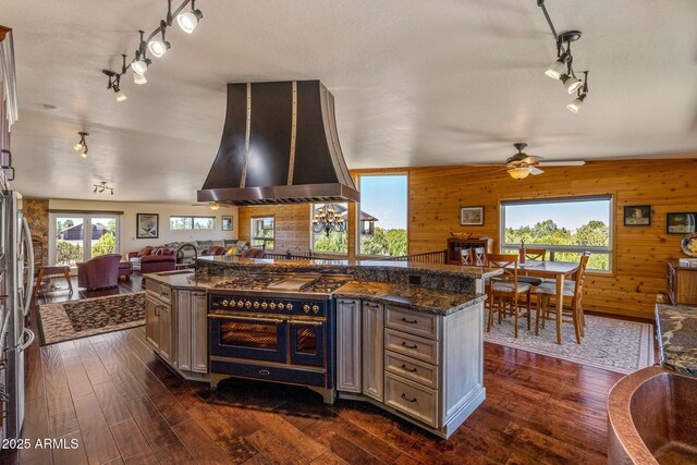2335 Voyager Cir, Overgaard, AZ 85933 - kitchen with ventilation hood, track lighting, range with two ovens, open floor plan, and a sink
